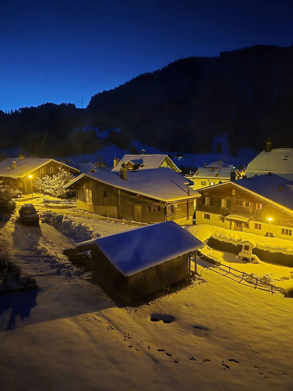 Le village de Rossinière enneigé et ses chalets éclairés la nuit